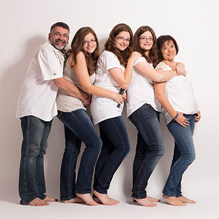 Eine Familie im Fotostudio lacht in die Kamera